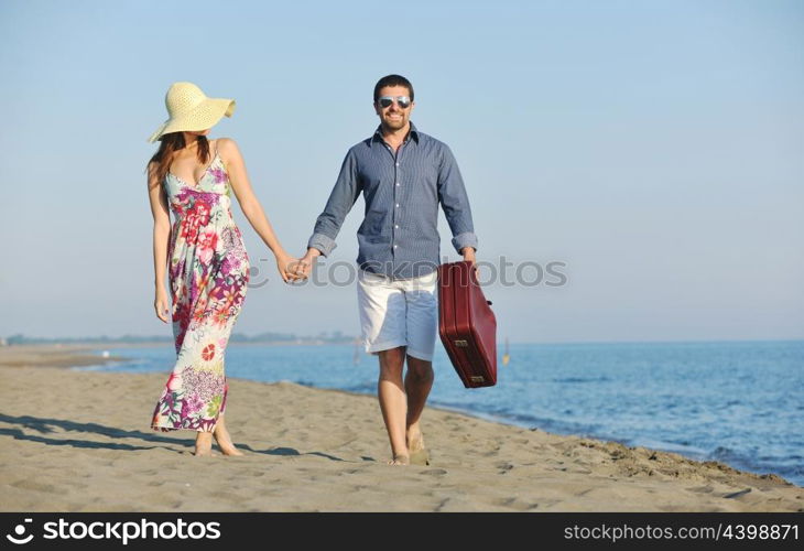 couple on beach with travel bag representing freedom and funy honeymoon concept