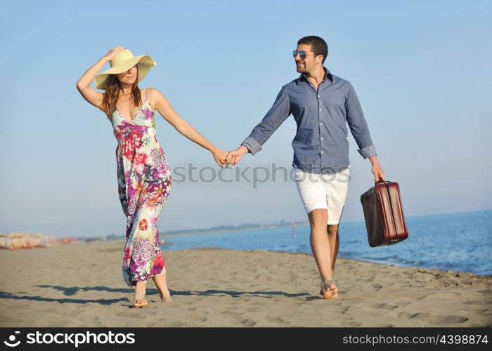 couple on beach with travel bag representing freedom and funy honeymoon concept