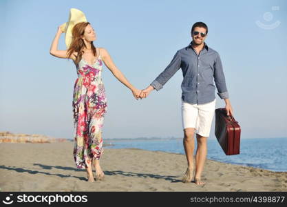 couple on beach with travel bag representing freedom and funy honeymoon concept