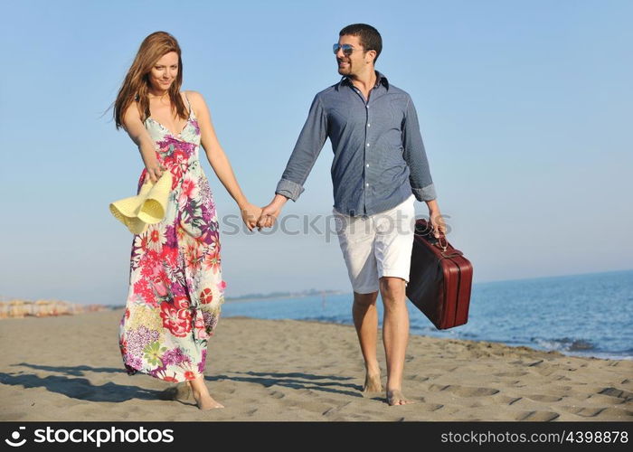 couple on beach with travel bag representing freedom and funy honeymoon concept