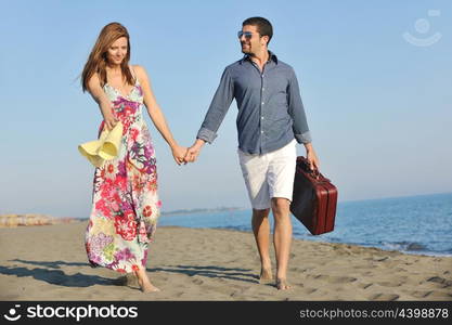 couple on beach with travel bag representing freedom and funy honeymoon concept