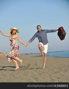 couple on beach with travel bag representing freedom and funy honeymoon concept