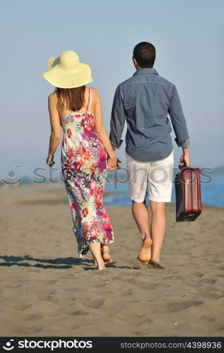 couple on beach with travel bag representing freedom and funy honeymoon concept