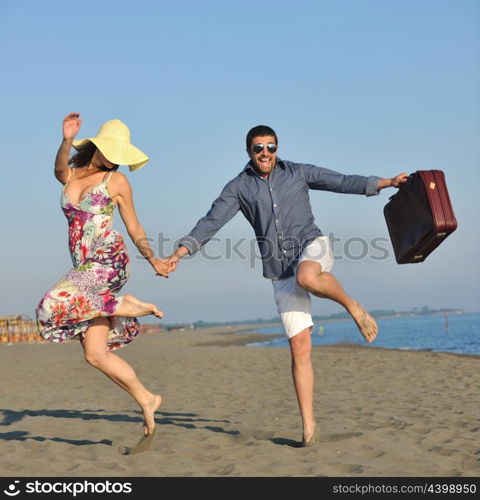 couple on beach with travel bag representing freedom and funy honeymoon concept