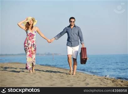 couple on beach with travel bag representing freedom and funy honeymoon concept