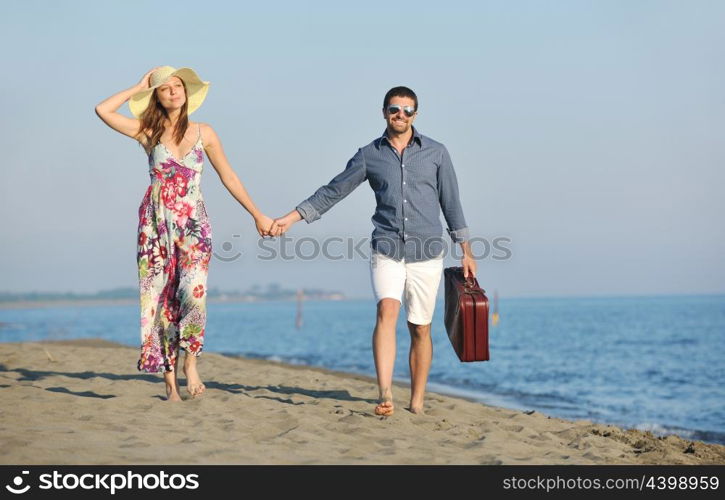 couple on beach with travel bag representing freedom and funy honeymoon concept