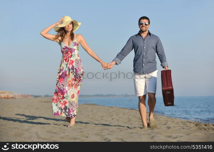 couple on beach with travel bag representing freedom and funy honeymoon concept