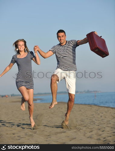 couple on beach with travel bag representing freedom and funy honeymoon concept