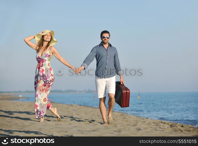 couple on beach with travel bag representing freedom and funy honeymoon concept