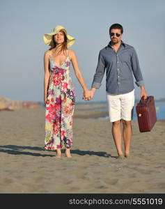 couple on beach with travel bag representing freedom and funy honeymoon concept