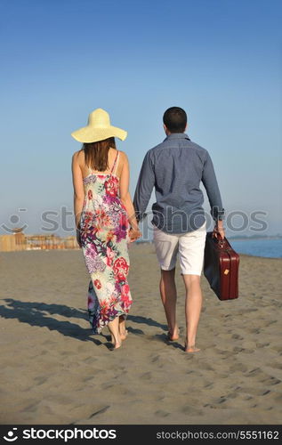 couple on beach with travel bag representing freedom and funy honeymoon concept