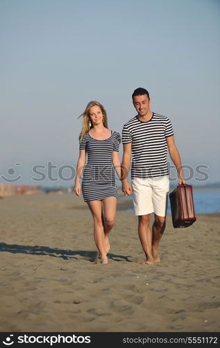 couple on beach with travel bag representing freedom and funy honeymoon concept