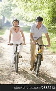 Couple on bikes outdoors smiling