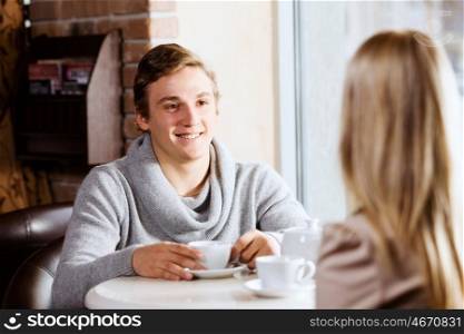 Couple on date. Young man sitting at table with girl at cafe