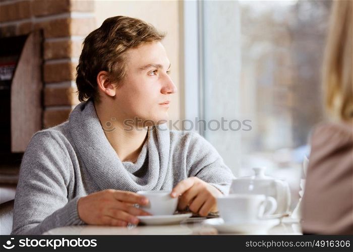 Couple on date. Young man sitting at table with girl at cafe