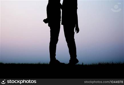 Couple on field with the silhouette at sky.