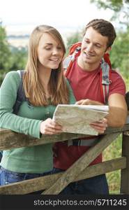 Couple On Hike Through Countryside Looking At Map