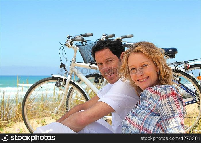 Couple on holiday sitting in front of bicycles