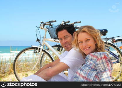 Couple on holiday sitting in front of bicycles