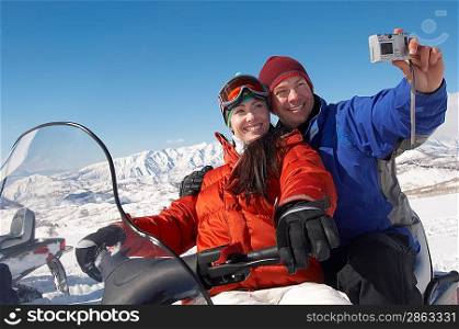 Couple on Snowmobile Taking a Photograph of Themselves