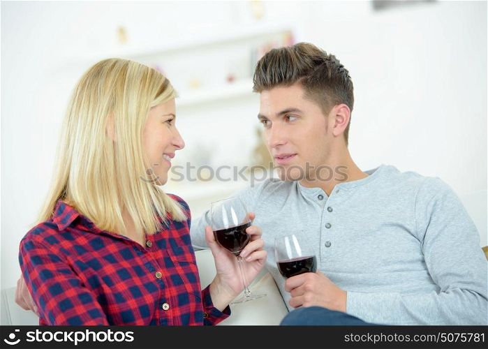 Couple on sofa holding wineglasses