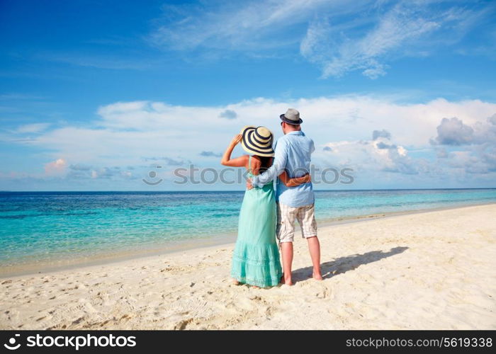 Couple on vacation walking on a tropical beach Maldives. Man and woman romantic walk on the beach.