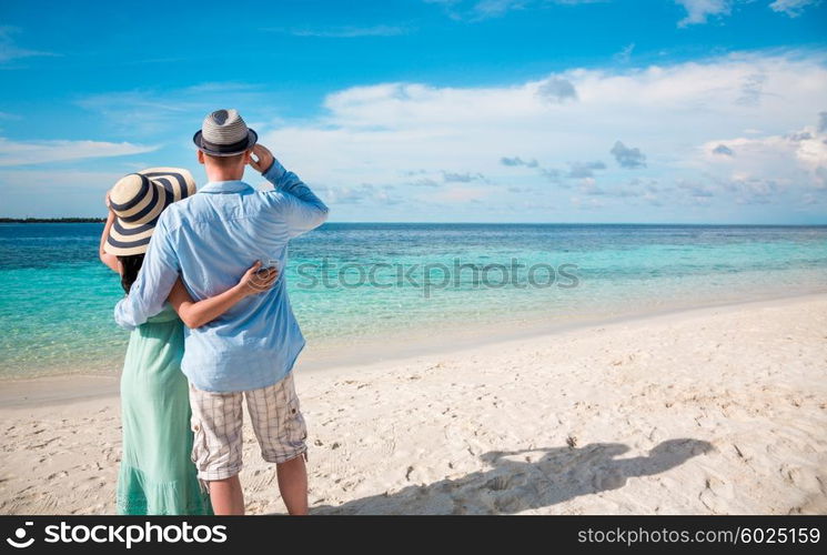 Couple on vacation walking on a tropical beach Maldives. Man and woman romantic walk on the beach.