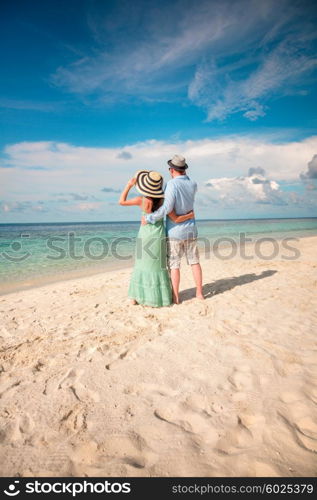 Couple on vacation walking on a tropical beach Maldives. Man and woman romantic walk on the beach.