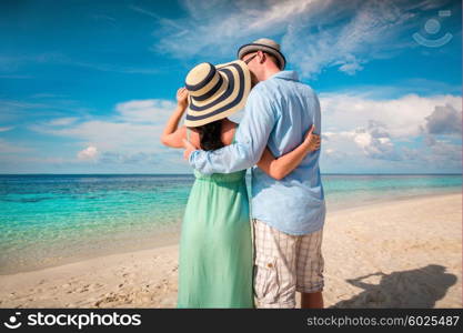 Couple on vacation walking on a tropical beach Maldives. Man and woman romantic walk on the beach.