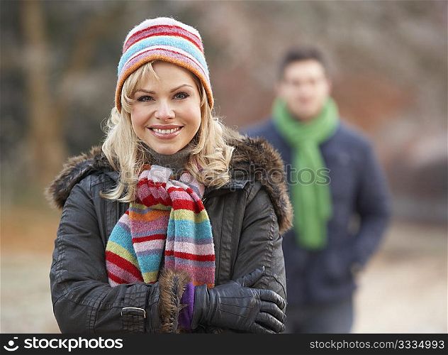 Couple On Winter Walk Through Frosty Landscape