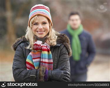 Couple On Winter Walk Through Frosty Landscape