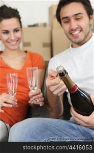 couple opening bottle of champagne