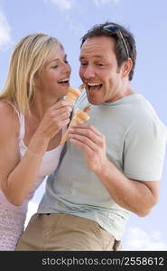 Couple outdoors eating ice cream and smiling