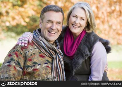 Couple outdoors embracing and smiling (selective focus)