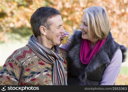 Couple outdoors in park bonding and smiling (selective focus)