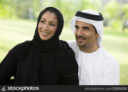 Couple outdoors in park smiling (selective focus)