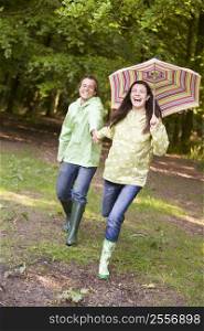 Couple outdoors running with umbrella smiling