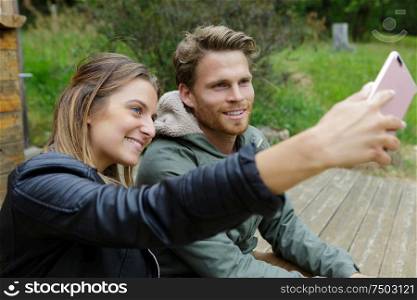 couple outdoors taking a selfie with smartphone