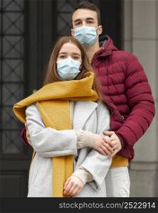 couple outside wearing medical masks