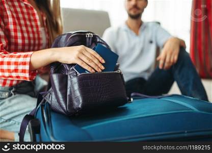 Couple packing their suitcases for vacation and take documents with them. Fees on journey concept. Luggage preparation. Couple packing their suitcases and take documents