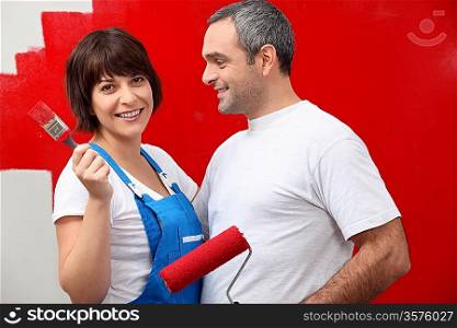 Couple painting a room bright red