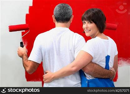 Couple painting wall in red