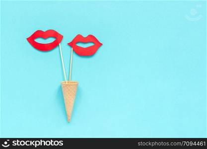 Couple paper lips props on stick in waffle cone on blue background. Concept lesbian love Creative Valentine&rsquo;s Day Greeting card Top view Copy space Template lettering, text or your design.. Couple paper lips props on stick in waffle cone on blue background. Concept lesbian love Creative Valentine&rsquo;s Day Greeting card Top view Copy space Template lettering, text or your design