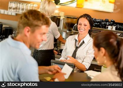 Couple paying bill at cafe cash desk smiling waitress bar