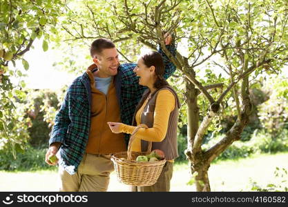 Couple picking apples in garden