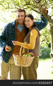 Couple picking apples in garden