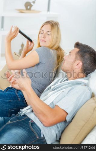 Couple play fighting on the sofa