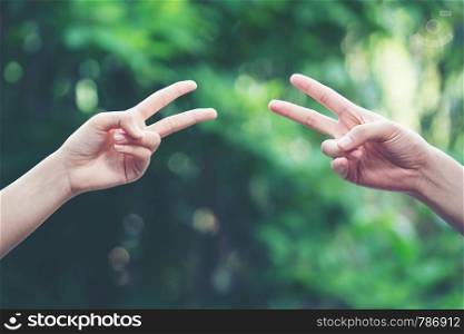 Couple play rock paper scissors hand game nature green background