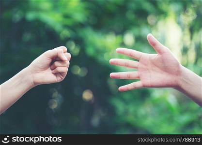 Couple play rock paper scissors hand game nature green background