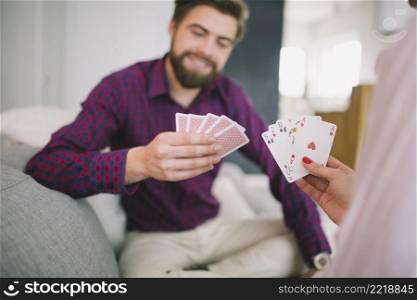couple playing cards sofa home